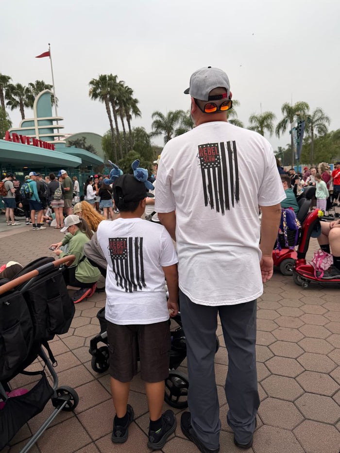 Dad and son wearing matching Rebel Scum flag tees, back view at Disney California Adventure