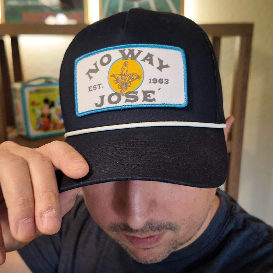Person wearing a black cap with 'No Way Jose' patch