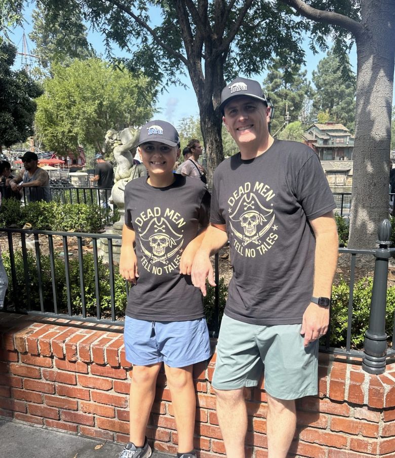 A dad and his son at the park in matching Dead Men Tell No Tales tees