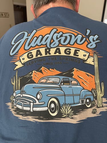 Back of a blue Hudson's Garage tee